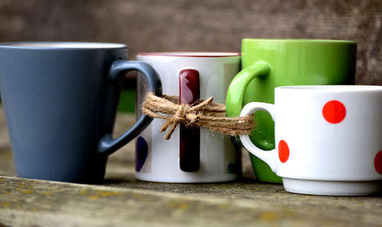 cups of various colors and shapes whose handles are tied together with a string